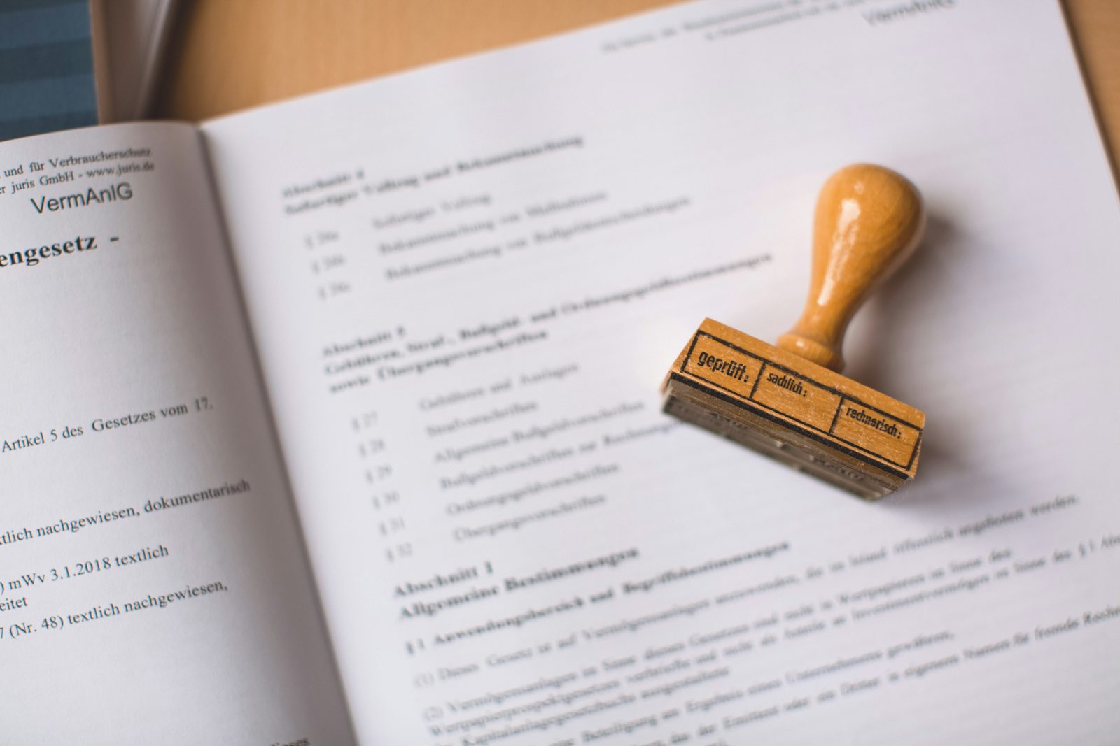 An approval rubber stamp resting on a bound volume of regulations